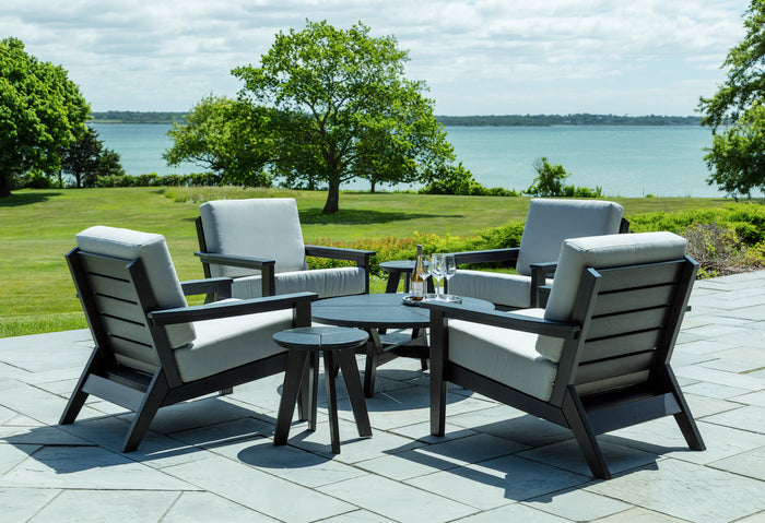 Round chat table in outdoor setting, heathered dark gray tabletop with four legs
