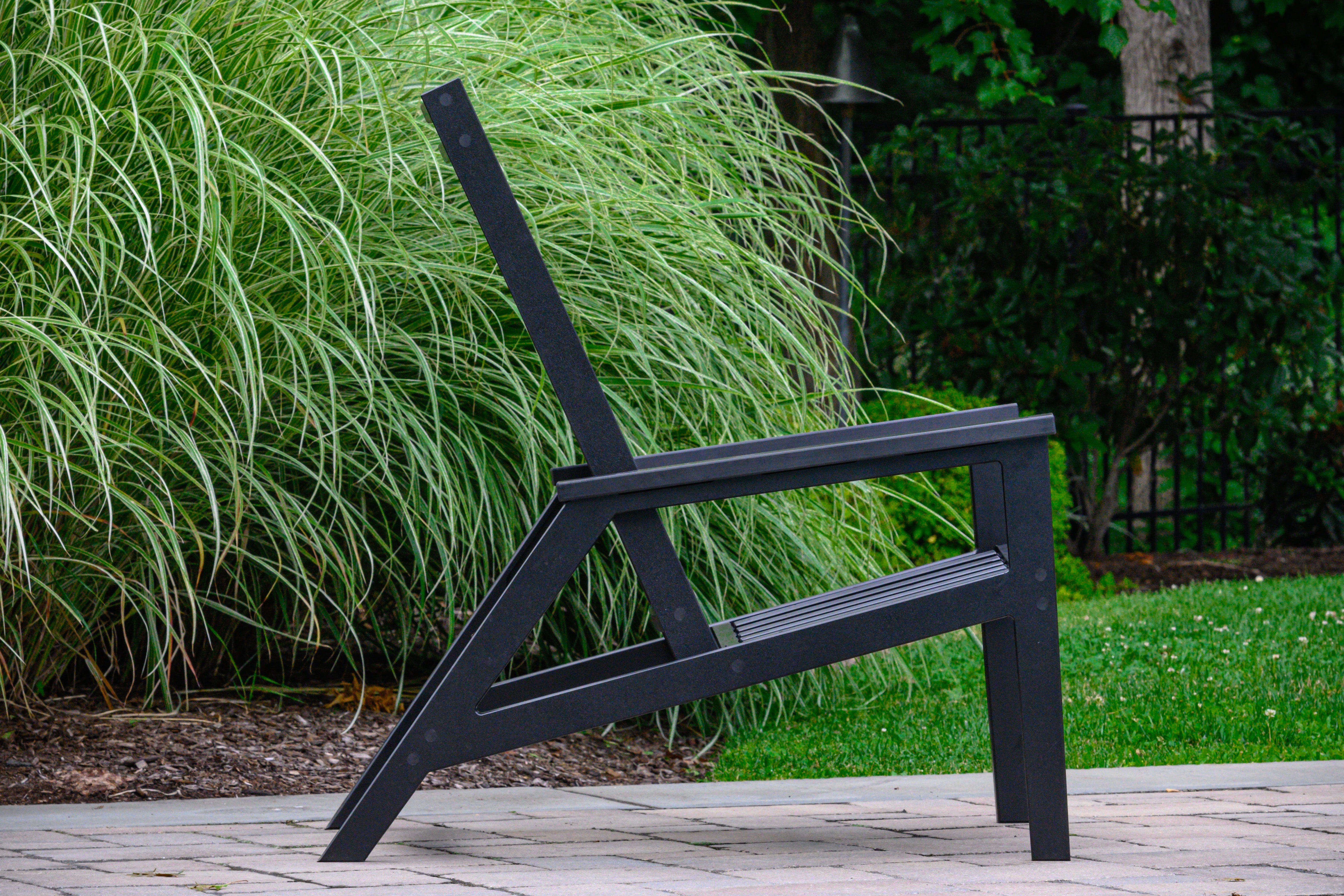 Charcoal recliner lounge chair with slatted back and seat, angled legs, armrests