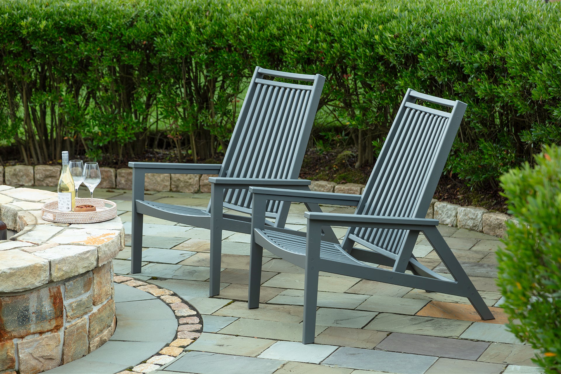 Reclining patio lounge chairs, two charcoal frames with slatted seats and backs